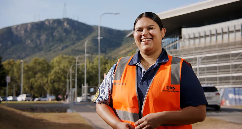 Breanne Saltner working outside the JCU Engineering & Innovation Place in Townsville wearing orange hi vis safety vest