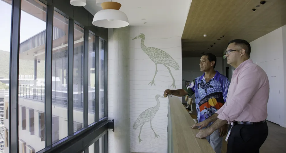 Indigenous Engagement employee talking with traditional owner at JCU Halls of Residence looking over landscape